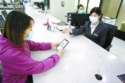  在东城区政务服务大厅，前来办事的企业工作人员通过“北京通”授权电子证照应用